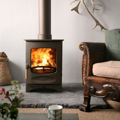 Charnwood C-Four Blu Woodburning Stove with an armchair beside it